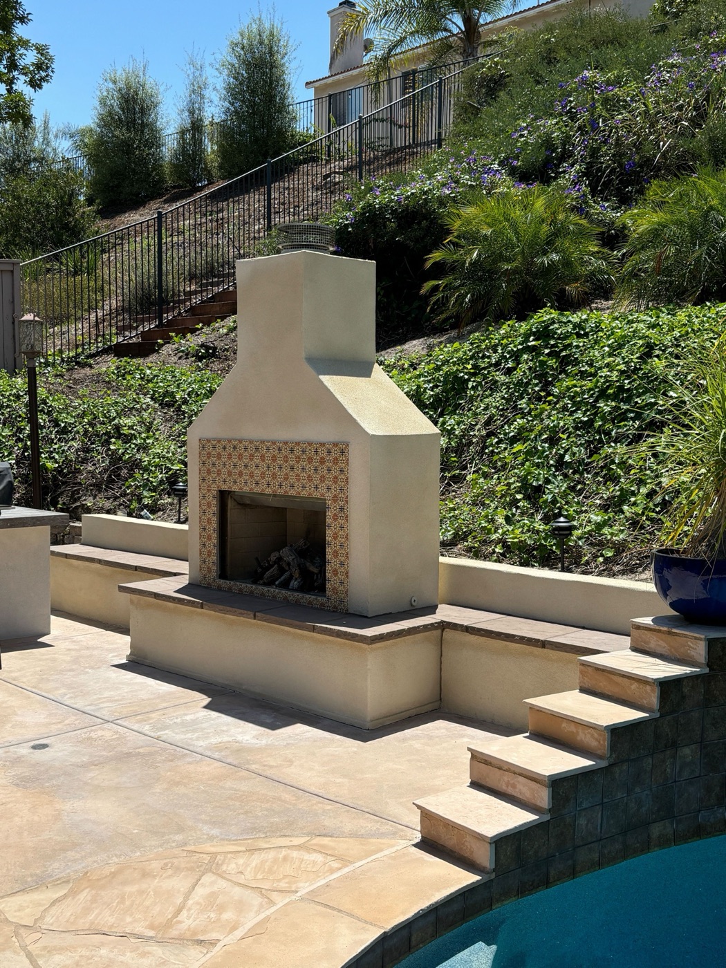 Outdoor fireplace on a hillside terrace in Kaplan by Abshire Brothers Lawn & Landscape